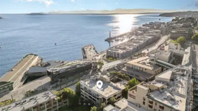 Behold the stunning aerial view from this Seattle waterfront condo, showcasing the serene Puget Sound with dazzling sunlight dancing on the waves and majestic Olympic Mountains in the distance. The photo highlights the building’s prime spot, marked by the home pin, nestled near vibrant piers and the new Waterfront Park. Surrounded by lush greenery and bustling streets, this location offers a perfect blend of natural beauty and urban convenience, with breathtaking water vistas at your doorstep!