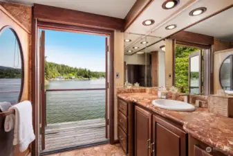 The primary bath has a large vanity and French doors that open to a private deck (the purpleheart wood is on order to replace some weathered wood).