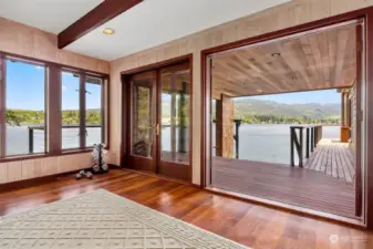 Looking out to the covered sitting area and the wraparound deck and the stairs that lead down to the dock, you can see the expansive purpleheart deck space on this floor alone!