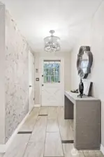 The entry way enjoys this cute front door, fun light fixture, and ceramic tile flooring.