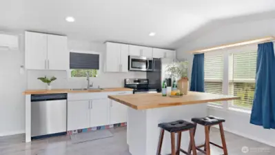The heart of the home truly shines with a spacious island, breakfast bar seating for casual meals or conversation, and stainless steel appliances ready to handle everything from quick snacks to weekend feasts!