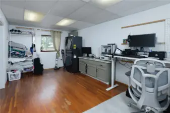 Spacious multipurpose room is being used as an office and laundry room.
