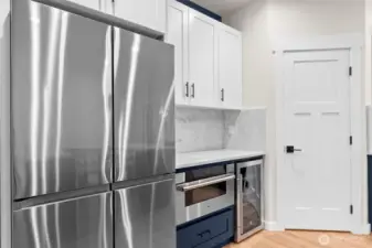 Samsung French door refrigerator equipped with beverage center. KoolMore microwave drawer and GE beverage fridge with oak shelves.