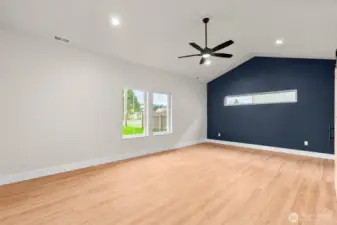 Inviting primary suite complemented by the vaulted ceiling, large windows, and ceiling fan.