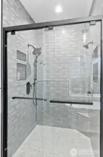 Custom walk-in shower featuring a 9” Moen rain shower head, multi-function handheld, and additional showerhead for a true luxury experience.