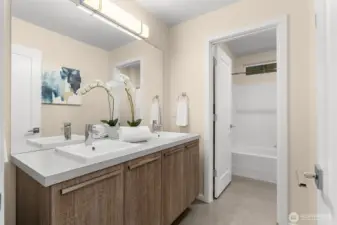 Hallway full bath with dual vanity.
