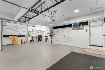 Oversized 3-car garage with EV chargers, garage wall slat storage and built-in overhead storage racks.