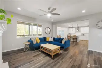 Considerably larger than this photo represents, this is the great room with open space to the very accommodating kitchen (much of it to the right of that wall that you see, with the clock on it). Note the open dining space in the background. Some people use that as an additional seating area, bottom line is… Very flexible space for you to utilize, design, and furnish the way you like! Or, change it up often, if you're "that type." TeeHee