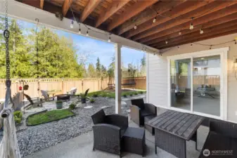 Ground-level patio is perfect for those lazy daze...check out the hammock hooks, night-lighting and plenty of outdoor furniture space. This patio is covered and those sliders to the right are into the downstairs bonus / media / workout room.