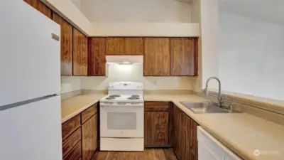 Galley style kitchen with rich cabinetry offering ample storage space and all appliances stay.