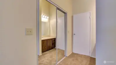 Mirrored closet doors & just beyond the door is the water closet with walk-in shower.