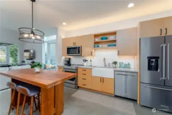 view 1 of kitchen w/ custom dining room table and high end cabinetry and appliances.