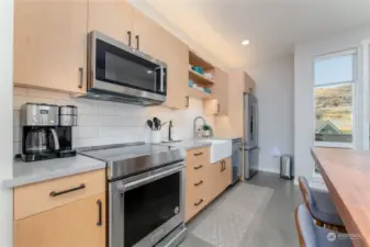 view 3 of kitchen w/ custom dining room table and high end appliances.