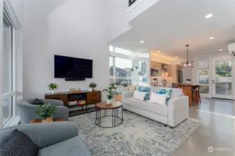 View 1 of the Great Room/Living Room w/ vaulted ceilings, oversized windows and doors leading to the outdoor living area.