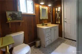 3/4 bath with shower off to the right and doorway leading to back porch.