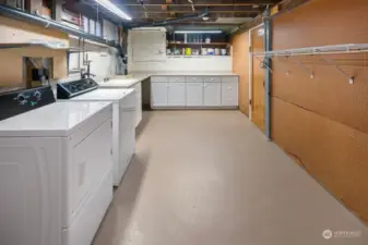 Basement laundry with ample cabinetry & counter space