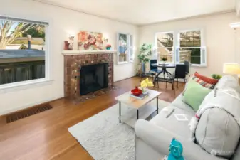 Open living area with wood-burning fireplace with original beautiful tile surround  & wall sconces