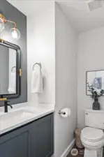 Main floor powder room with custom floating vanity and quartz countertops