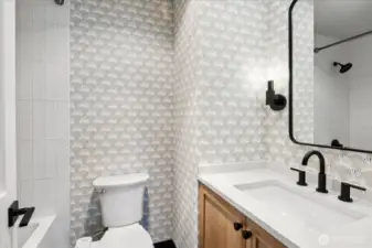 Upstairs guest ensuite bathroom with wallpaper, custom floating vanity, new tile and quartz countertops