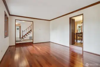 Living room looking toward entry and stairs to upper floor, dining area off kitchen is on the right. Floors are Brazilian Cherry hardwood