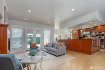 Light-filled great room with French doors opening to a private backyard retreat featuring a soothing water feature, relaxing hot tub, and stamped concrete covered patio—perfect for indoor-outdoor living.
