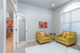 Another view of the private sitting area off the primary suite, featuring French doors, abundant natural light, and flexible space for reading, quiet work, or relaxation.