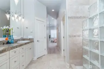 Another view of the expansive primary bath, showcasing its spacious layout, glass-block shower, and elegant finishes—designed to feel both open and luxurious.