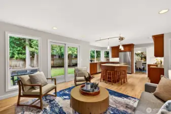 Large windows and sliding door access make it easy to step outside and enjoy the private, evergreen bordered yard, while the open connection to the kitchen keeps entertaining seamless.