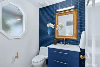 The main floor half bath was fully renovated in 2021, featuring a striking tile accent wall, a modern vanity, and updated fixtures that feel crisp and current.