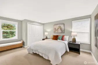 A bright bedroom with ample closet storage and custom window blinds offers a comfortable, private place to unwind, study, or create.