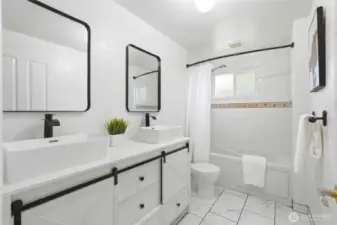 The main bathroom has been tastefully refreshed to reflect a more modern aesthetic. A new vanity provides both style and practical storage. The updated mirror enhances the space, adding a clean and polished look.