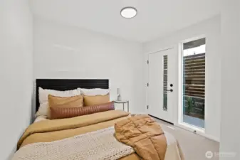 Lower level bedroom with access to back patio. Model home. Colors and finishes may vary.