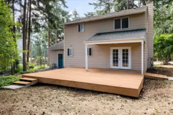 Back Deck with steps leading towards spacious outbuilding.