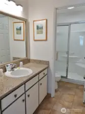 Bathroom w/ tile floors and walk-in shower.