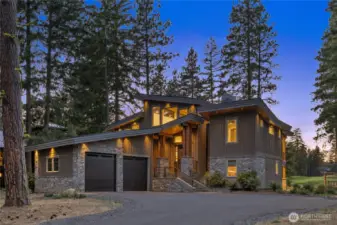Twilight photo of Contemporary architecture with timeless appeal. The striking stone-and-concrete entry welcomes you home.