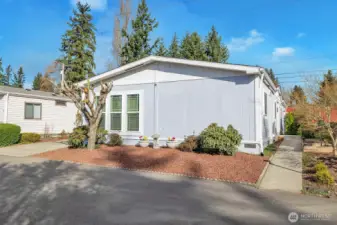 Street view of this level entry home in the desirable Park Wood Lane 55+, gated community. Energy efficient heat pump with AC for your year-round comfort and savings.  Easy care landscaped yard. Home is bordered by mature trees, plants and shrubs that bring "year-round" color and greenery.
