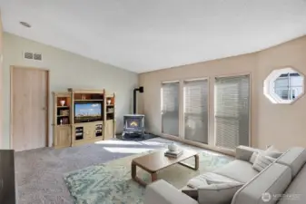 Open and light formal living room is warm and inviting. Cozy up the standing stove on those chilly Washington days.  Room will easily accommodate love seat, recliners and addtional furniture for your comfort. Floor to ceiling, vinyl windows bring in notable natural lighting. Neutral color scheme on walls will match with any furniture design and pattern. Virtually staged.