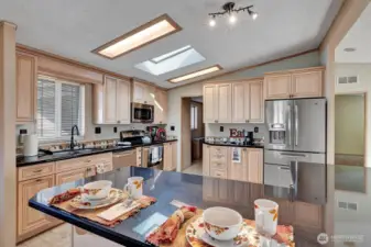 Chefs delight, updated, modern kitchen. Large island with storage below. Cabinets have pullouts for your convenience. Mixer cabinet with pullup and power for all your baking needs. Built in wine rack. Open ledge storage areas. Ample prep and storage space in this spectacular kitchen. Coffee bar or butler station too! All appliances are newer stainless steel. This kitchen is HUGE! Room for more than one Cook to be working at one time.