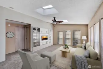 Family room at the south end of the home. Light and bright room has skylights and 6 floor to ceiling windows for natural lighting. Room for Big Screen TV, sofa's, recliners, coffee tables and more. Carpet is neutral color and like new. Great room for entertaining. Virtually staged.