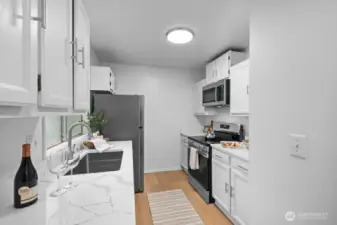 The beautifully remodeled kitchen shines with refreshed cabinetry, sleek quartz countertops, new appliances, and modern flooring throughout.