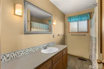 Full bath has generous countertop, quartz counter, custom splash and custom tile flooring