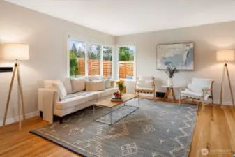 Fabulous living room space - feels large. The newer windows (2024) facing southeast allow the natural light to flood in and shine on the refinished floors.