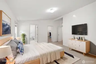 Primary bedroom with view to bathroom and walk-in closet (virtually staged)