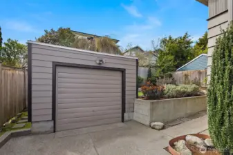 The detached garage, with a sidewalk leading to the backyard and patio.