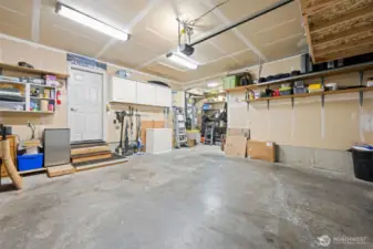 The garage features a generous workshop area, storage cabinets and lots of light.