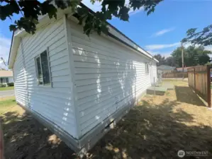 Vinyl siding and poured concrete foundation. Backside of the home.