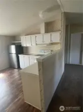 Kitchen area with refrigerator and dishwasher and a space for smaller kitchen table.