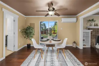 The dining area features sliding glass doors that open directly to the back deck and yard, creating seamless indoor-outdoor flow. A ceiling fan and mini-split system provide comfort year-round, while hardwood floors add warmth and durability.