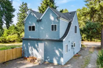 Rear view of the home shows the charming exterior design along with easy driveway access to the garage and parking area. This layout ensures convenience and functionality for everyday living.