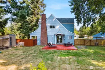 A full view of the backyard highlights the size and open feel, complete with a deck and fenced yard that’s ready for gatherings and activities.